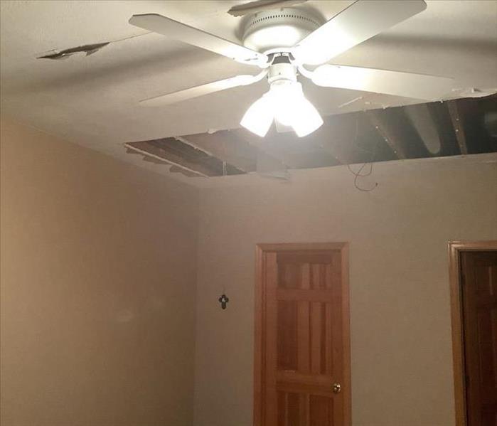ceiling with a big hole in it from water damage