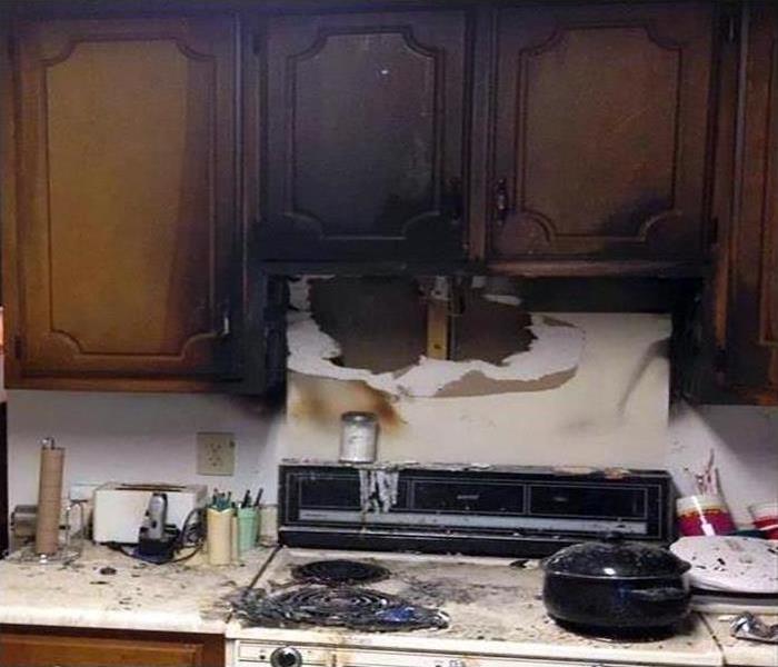 A kitchen counter covered in soot and smoke damage after a fire